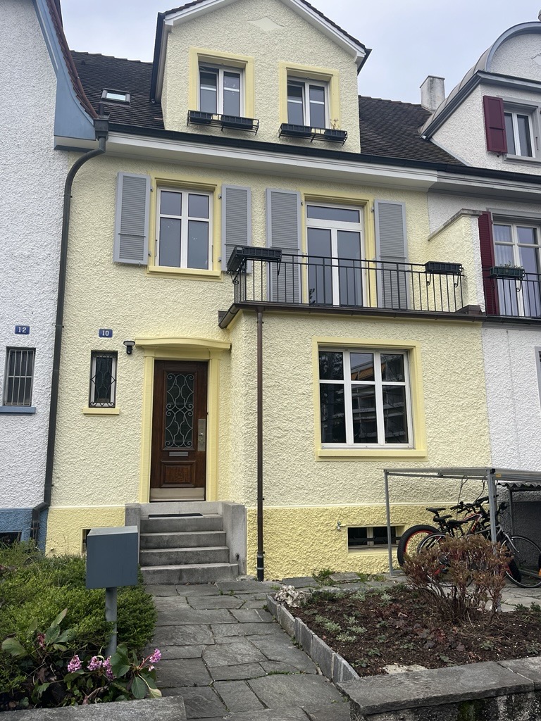 Gelblich gestrichene Hausfassade mit Fensterläden